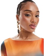 Limited Edition drop earrings with abstract ribbon detail in gold tone