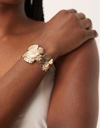 cuff bracelet with floral detail in gold tone